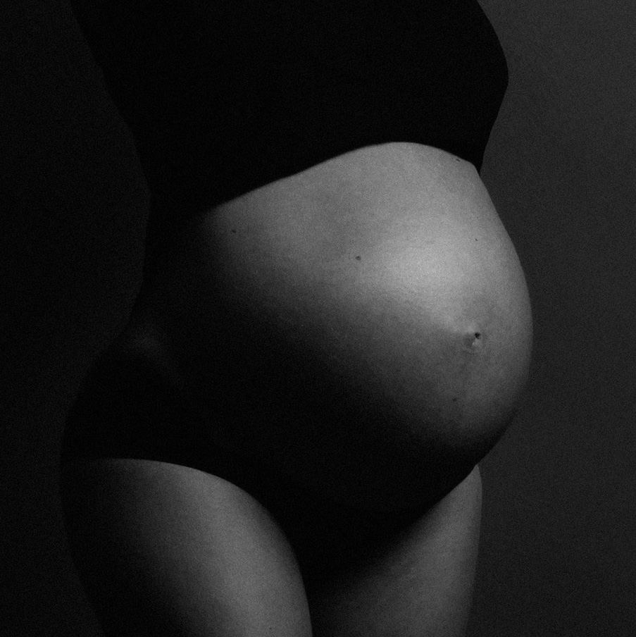 Ventre de femme enceinte en clair-obscur